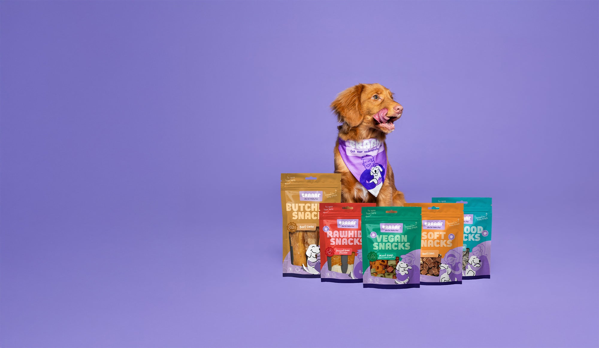 Hond likt zijn lippen heeft vijf verschillende verpakkingen van Braaaf voor zich staan