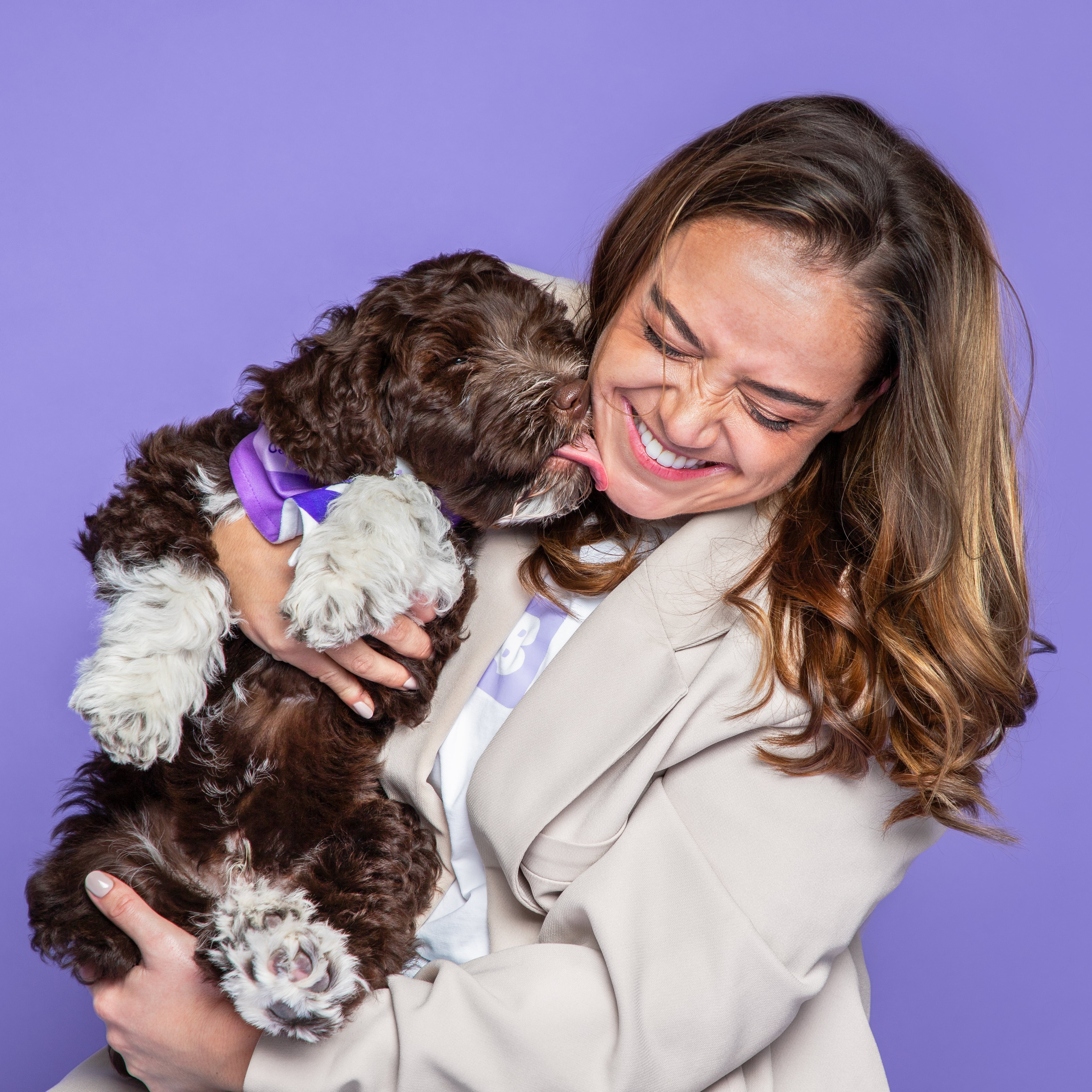 Hond likt lachende vrouw, paarse achtergrond