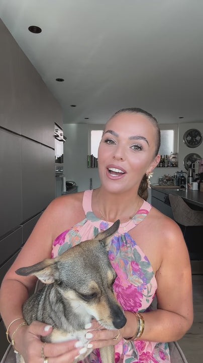 Laura Ponticorvo heeft haar hondje Gigi op schoot en spreekt de kijker aan over de vakantiebox van Braaaf.